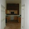 An apartment entry hall with kitchen beyond